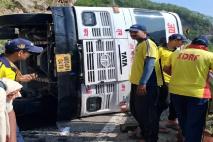 Char Dham Bus Accident: Overturned Char Dham pilgrimage bus near Totaghati in Tehri Garhwal after brake failure, with rescue teams assisting passengers at the accident site.