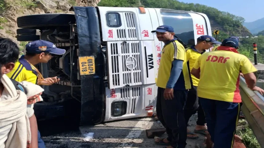 Char Dham Bus Accident: Overturned Char Dham pilgrimage bus near Totaghati in Tehri Garhwal after brake failure, with rescue teams assisting passengers at the accident site.