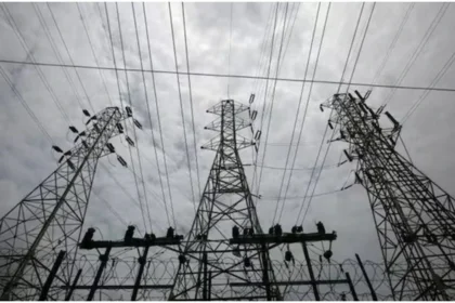Delhi Electricity Price Hike: Electricity meter and power transmission lines representing hike and increased electricity bills in Delhi.