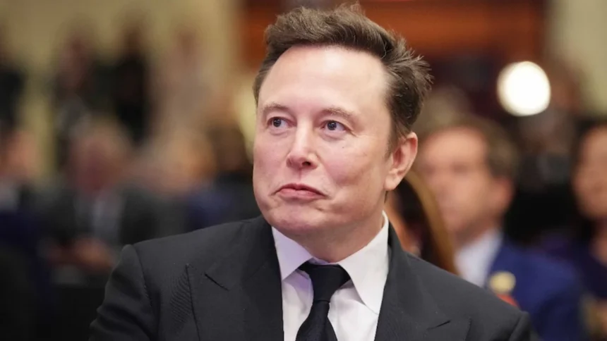Elon Musk Net Worth speaking at an event as SpaceX shares surge following its Nasdaq listing, pushing his net worth above $1 trillion.