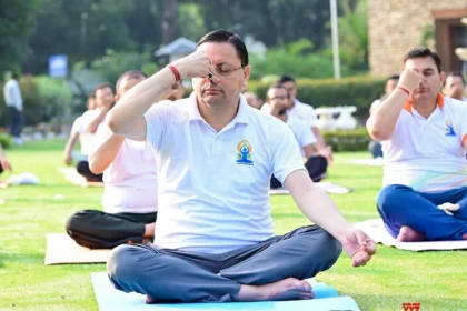 CM Dhami performing yoga with thousands of participants during International Yoga Day 2026 celebrations in Banbasa, Champawat.